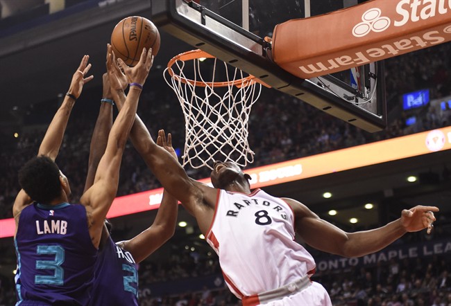 Charlotte Hornets' Al Jefferson, Jeremy Lamb (3) and Toronto Raptors' Bismack Biyombo (8) battle for a rebound during first half NBA basketball action in Toronto on Tuesday, April 5, 2016. THE CANADIAN PRESS/Frank Gunn.