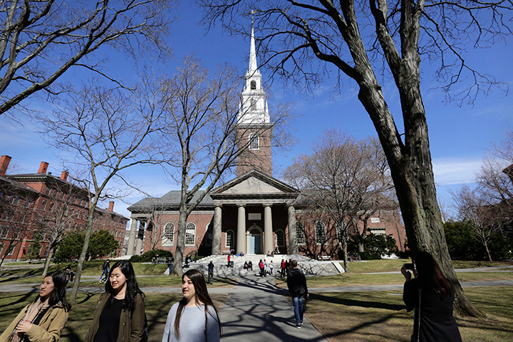 In this Sunday, March 13, 2016 photo, people walk near Memorial Church on the campus of Harvard University, in Cambridge, Mass. 