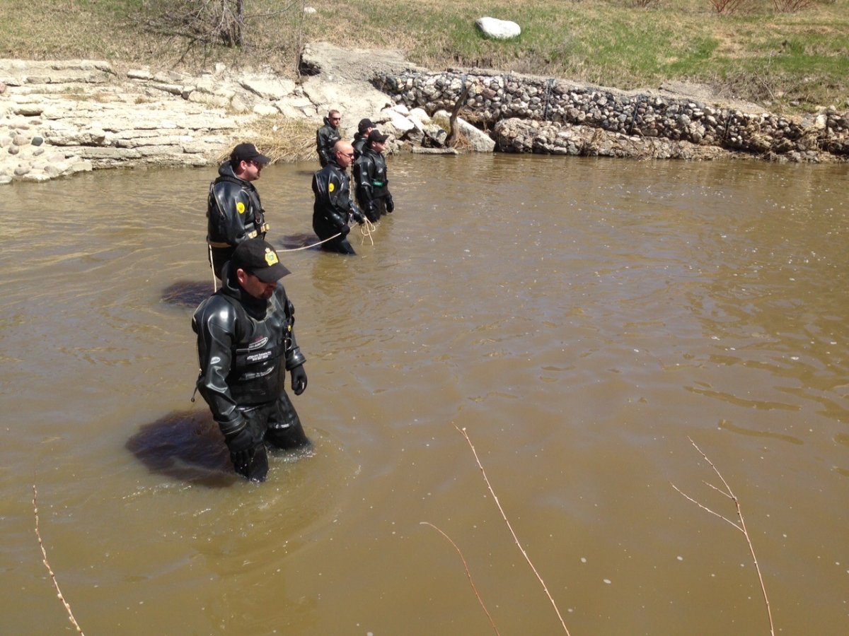 Winnipeg Police dive teams in Sturgeon Creek Friday .