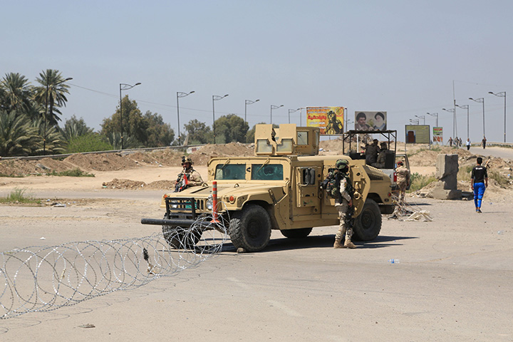 Iraqi army stand guard at the site of a suicide attack targeting a checkpoint in Baghdad Iraq, Monday, April 4, 2016. 