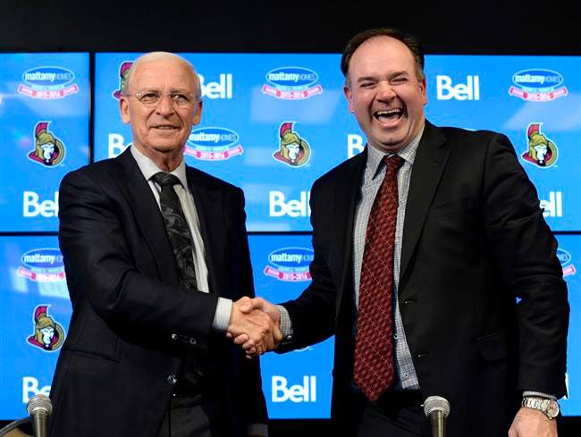 Ottawa Senators former general manager Bryan Murray shakes hands with incoming general manager Pierre Doiron (right) following a press conference in Ottawa, Sunday, April 10, 2016.