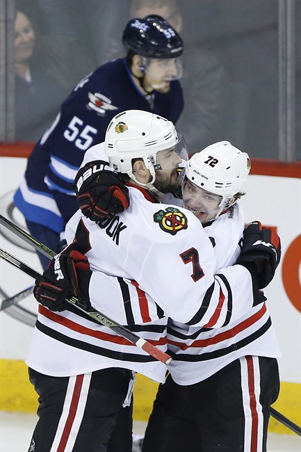 Chicago Blackhawks' Artemi Panarin (72) and Brent Seabrook (7) celebrate Seabrook's game winning goal against the Winnipeg Jets during overtime NHL action in Winnipeg on Friday, April 1, 2016. 