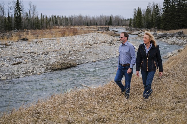 Lee Drewry, left, and Mary Robinson walk along the Elbow River where a reservoir will be if government plans go ahead, near Bragg Creek, Alta., Friday, April 8, 2016.
