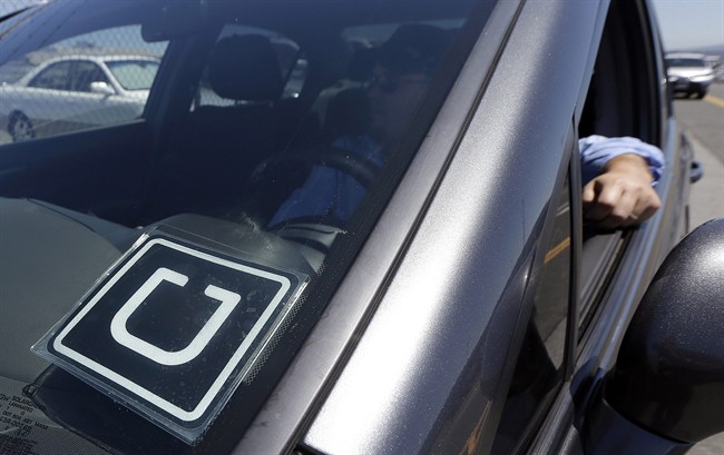 In this July 15, 2015 file photo, an Uber driver sits in his car near the San Francisco International Airport.