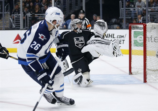 Winnipeg Jets right wing Blake Wheeler, left, watches as he misses a shot-attempt while Los Angeles Kings goalie Jonathan Quick, right, protects the net during the first period of an NHL hockey game, Saturday, April 9, 2016, in Los Angeles.