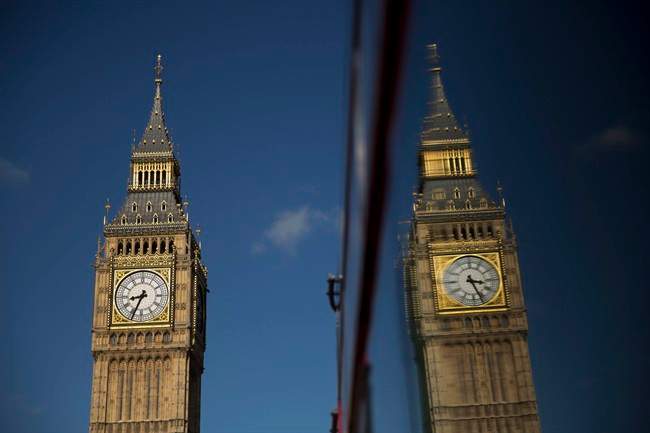 Elizabeth Tower, which houses the Big Ben bell, at the Houses of Parliament is reflected in a bus window in London, Tuesday, April 26, 2016. 
