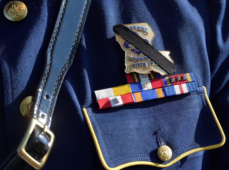The badge of Louisiana State Police Officer Brett Travis is covered with a black band in remembrance of slain Kentucky State Police Trooper Joseph Cameron Ponder at the Severns Valley Baptist Church in Elizabethtown, Ky., Friday, Sept. 18, 2015. 