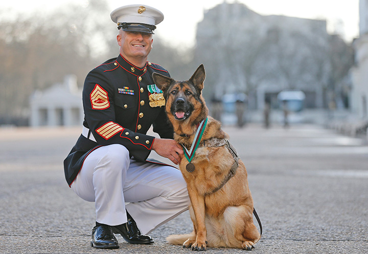 Sergeant Christopher Willingham, of Tuscaloosa, Alabama, poses with US Marine dog Lucca, after receiving the PDSA Dickin Medal at Wellington Barracks in London, England on Tuesday, April 5, 2016.