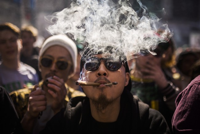 A man smokes marijuana during the "420 Toronto" rally in Toronto, Wednesday April 20, 2016. 