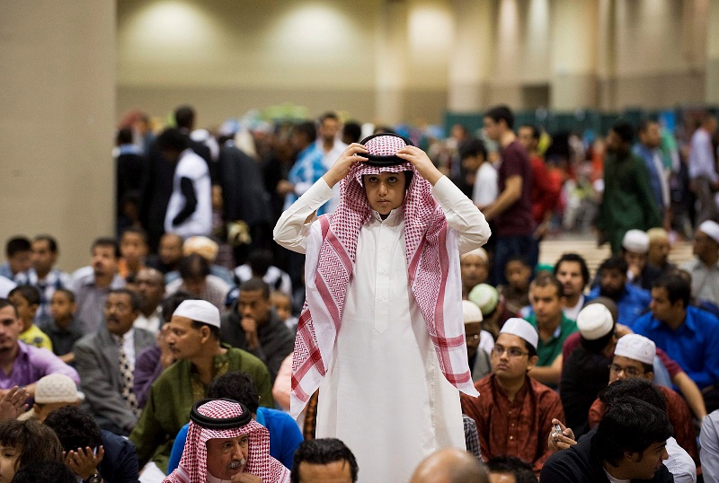 A boy puts on his head dress at the Muslim Association of Canada's Eid celebration that marks the end of the holiday of Ramadan at the Metro Convention Centre in Toronto on Tuesday, August 30, 2011.