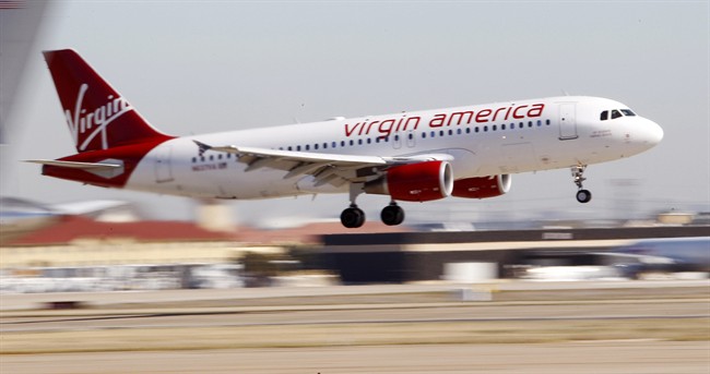 In this Dec. 1, 2010, file photo, Virgin America’s inaugural flight between Los Angeles and Dallas Fort Worth International Airport comes in for a landing in Grapevine, Texas.
