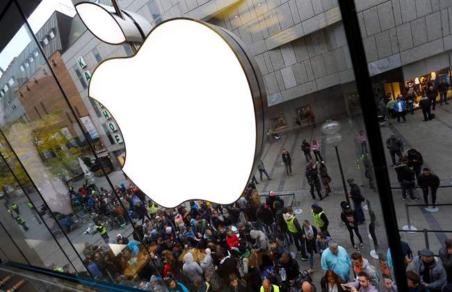 People wait in front of the Apple store in Munich.