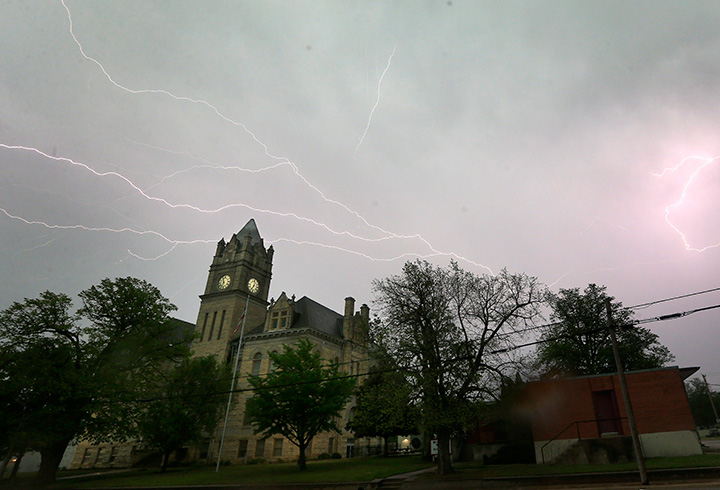 Lightning illuminates the sky over the Marion County Courthouse in Kansas, Tuesday, April 26, 2016.