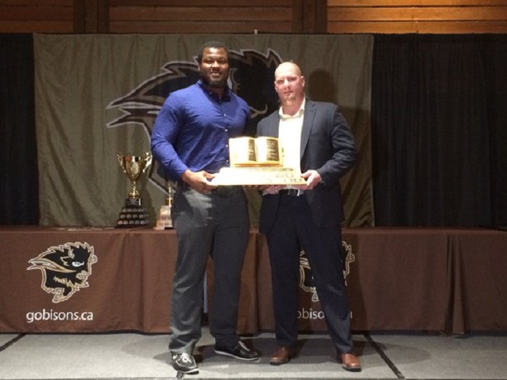 Defensive lineman David Onyemata is handed the Manitoba Bisons male athlete of the year award.