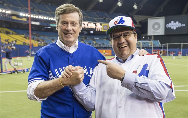 Montreal Mayor Denis Coderre, right, shares a laugh with Toronto counterpart John Tory prior to the Blue Jays facing the Boston Red Sox in a spring training baseball game in Montreal.