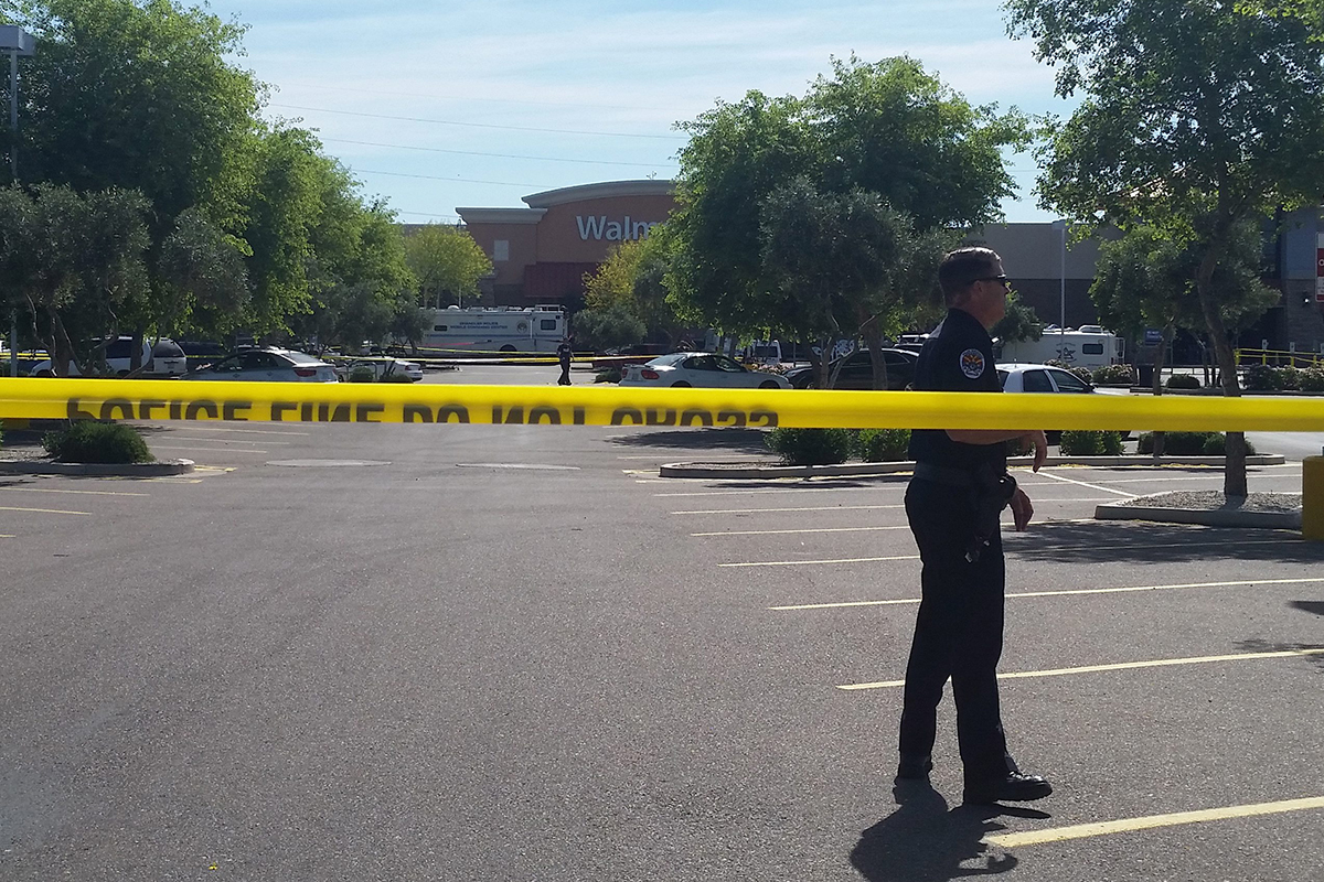 Chandler police spokesman Seth Tyler stands behind crime tape at the scene of a police involved shooting at a Walmart store on Saturday, April 23, 2016 in Chandler, Ariz. 