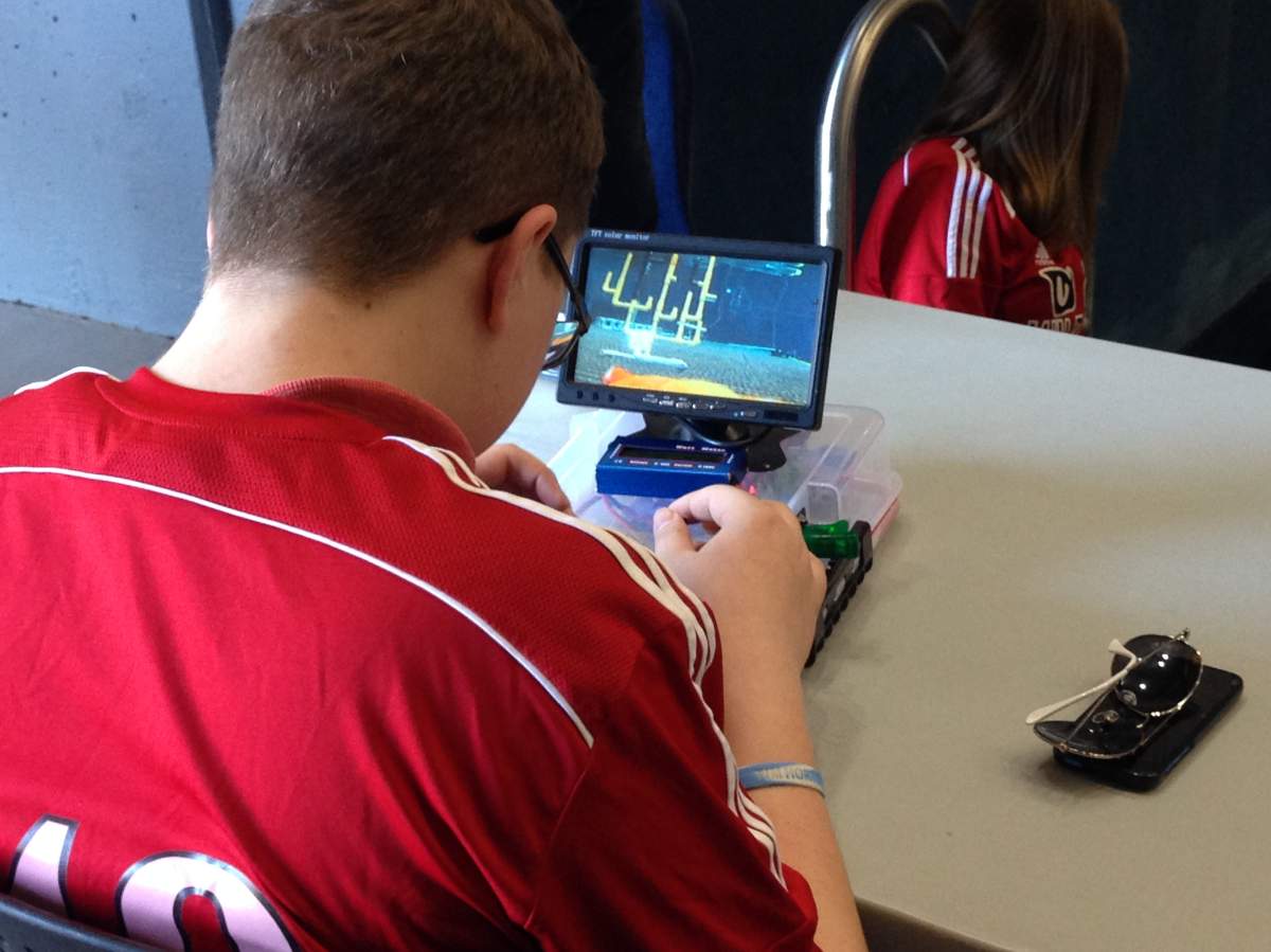 A student controls an underwater robot via remote control.