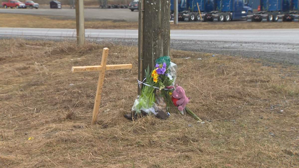 FLowers are seen at a memorial for the tree victime of a crash at the intersection of Route 112 and Homestead Road near Salisbury, New Brunswick. 