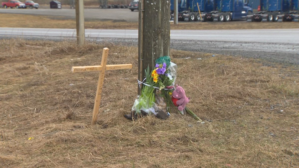 FLowers are seen at a memorial for the tree victime of a crash at the intersection of Route 112 and Homestead Road near Salisbury, New Brunswick. 