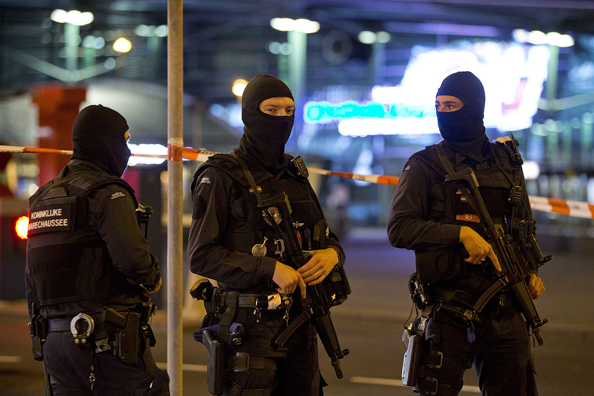 Hooded military police officers guard a part of Schiphol Aiport in Amsterdam, Netherlands, Wednesday, April 13, 2016. Military police have arrested a man and are conducting an investigation at Amsterdam's Schiphol Airport after a report of a "suspicious situation."  .