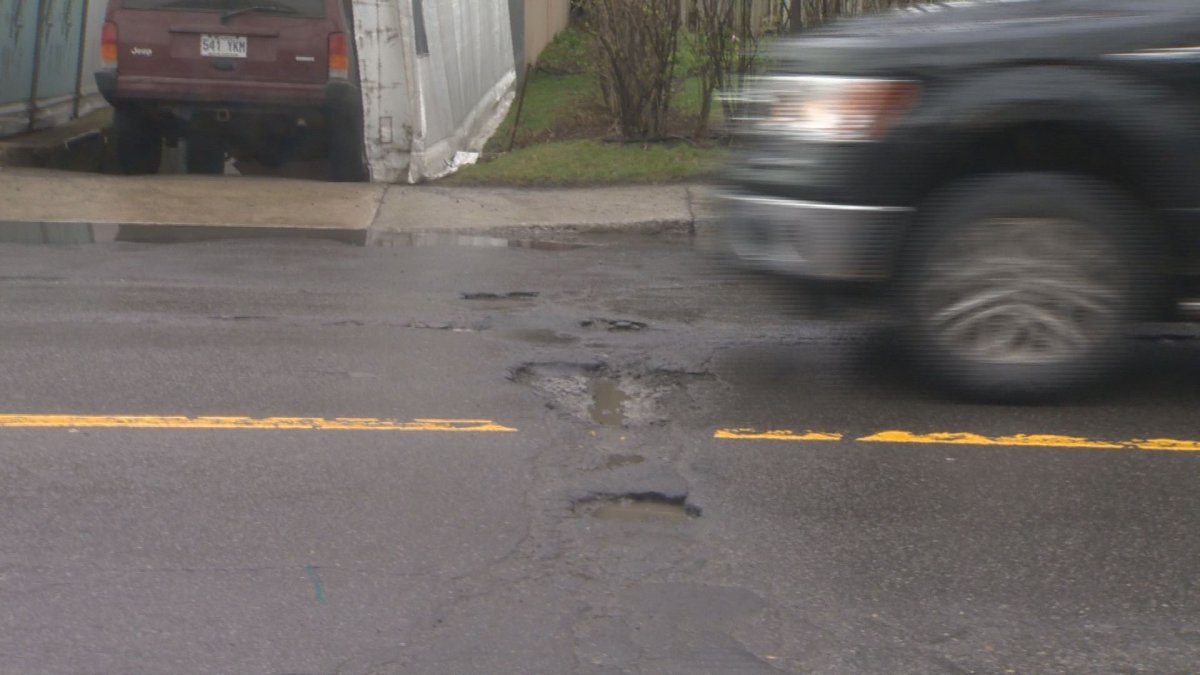 A truck is about to drive over a pot hole in Côte-des-Neiges.