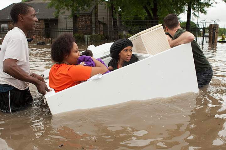 Residents evacuate their flooded apartment complex in a refrigerator on Monday, April 18, 2016, in The Woodlands, Texas.