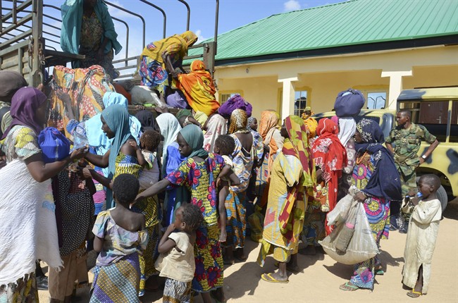 In this July 30, 2015, file photo, women and children rescued by Nigerian soldiers from the Islamic extremist group Boko Haram in the northeast of Nigeria, arrive at the military office in Maiduguri, Nigeria.