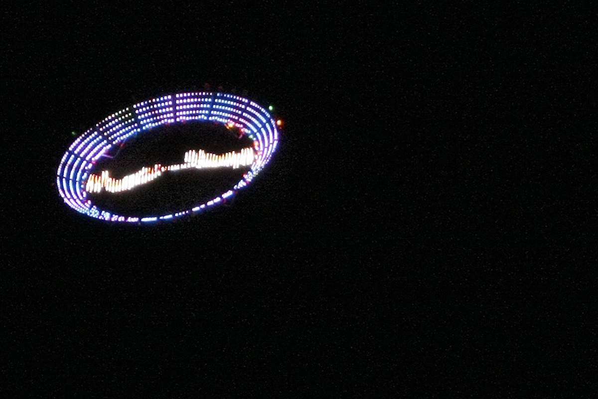 US plastic artist Peter Coffin's "Flying Saucer" --a 7-meter, LED-studded, SMS-controlled flying saucer and lifted by a helicopter-- overflies Ipanema beach, on May 23, 2009, in Rio de Janeiro, Brazil. 