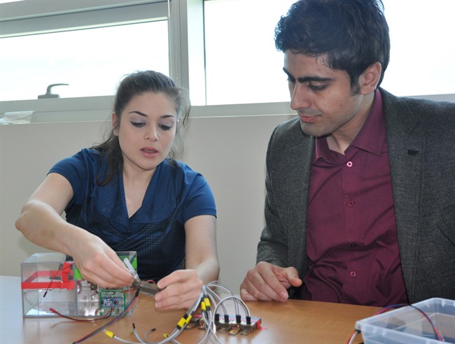 University of British Columbia engineering Professor Mina Hoorfar, who helped develop a breathalyzer to detect THC levels among motorists suspected of cannabis-impaired driving, works on a prototype of the device as PhD student Mohammed Paknahad looks on in a handout photo.