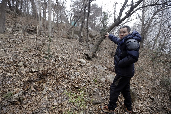 In this Jan. 28, 2016, photo, Lee Chae-sik talks as he walks up a hill behind a row of apartments at the former location of the Brothers Home, a mountainside institution where some of the worst human rights atrocities in modern South Korean history took place, in Busan, South Korea