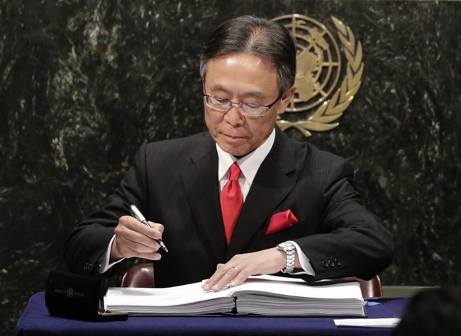 Motohide Yoshikawa, Japan's United Nations Ambassador, signs the Paris Agreement on climate change, Friday, April 22, 2016 at U.N. headquarters. (AP Photo/Mark Lennihan).