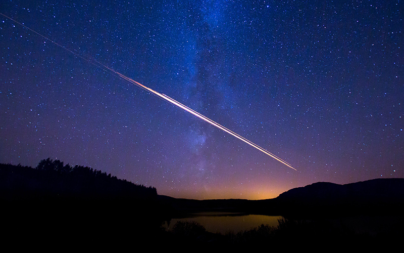 Comet and Milky Way over Clattingshaws Loch, Scotland.