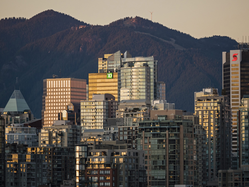  auringonlaskun värit heijastuvat Vancouverin täpötäyden keskustan horisontin lasista,