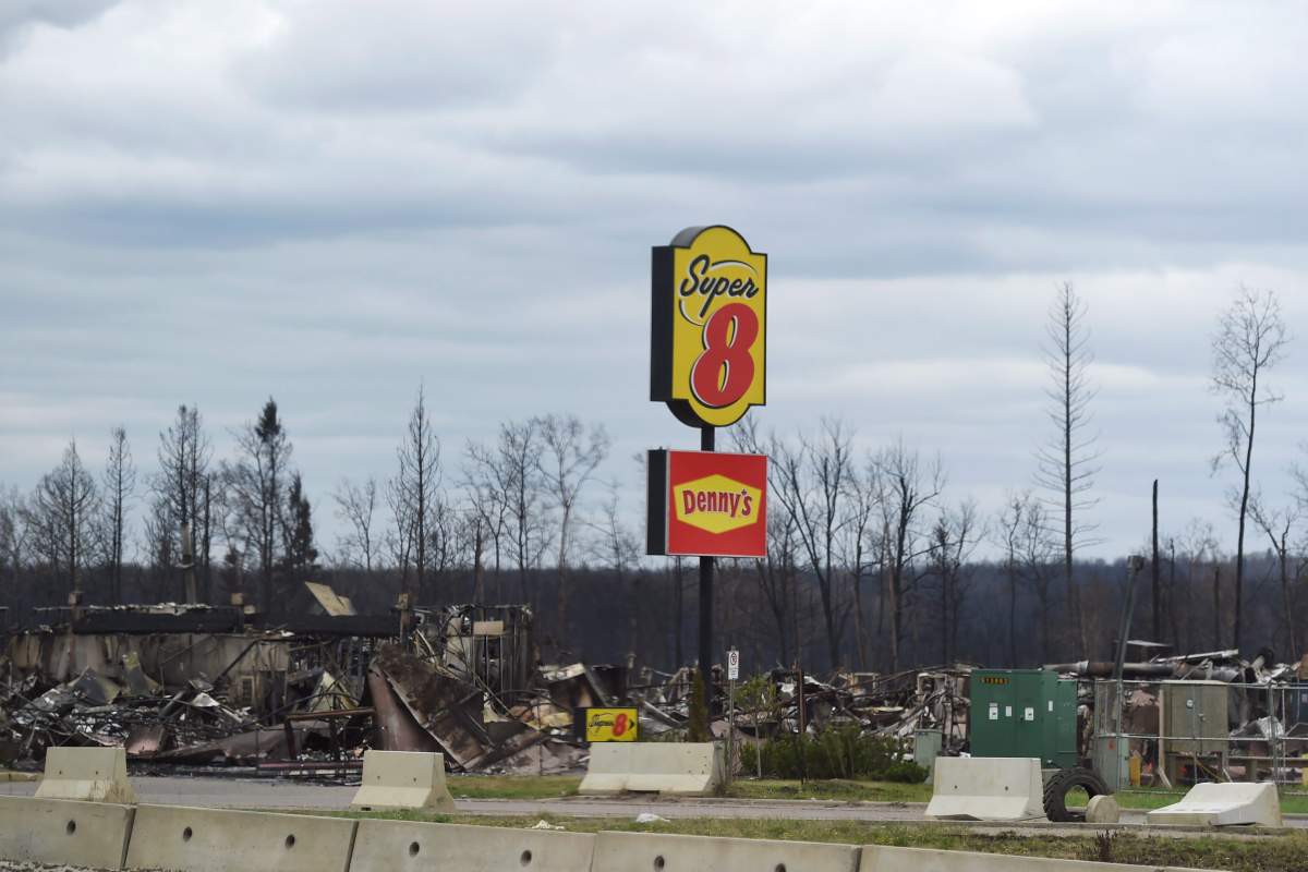A restaurant sign is all that is left standing in Fort McMurray, Alta. during a media tour of the fire-damaged Alberta city on Monday, May 9, 2016.