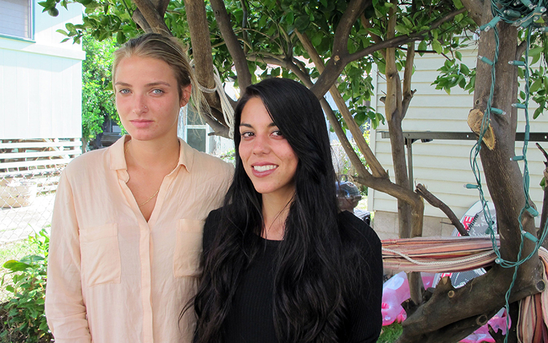 Courtney Wilson, left, and Taylor Guerrero posing for a photo in Honolulu.  Honolulu will pay $80,000 to settle a lesbian couple's lawsuit alleging a city's police officer wrongfully arrested them after seeing them kissing in a grocery store while on vacation. The settlement was announced Friday, May 20, 2016, in federal court in Honolulu. 