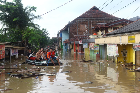 Rescue team on the boat is seen in the flooded street as they evacuates trapped people at Pondok Gede Permai residential area in Bekasi, near the capital Jakarta, Indonesia, on April 22, 2016.(Photo by Agoes Rudianto /Anadolu Agency/Getty Images).
