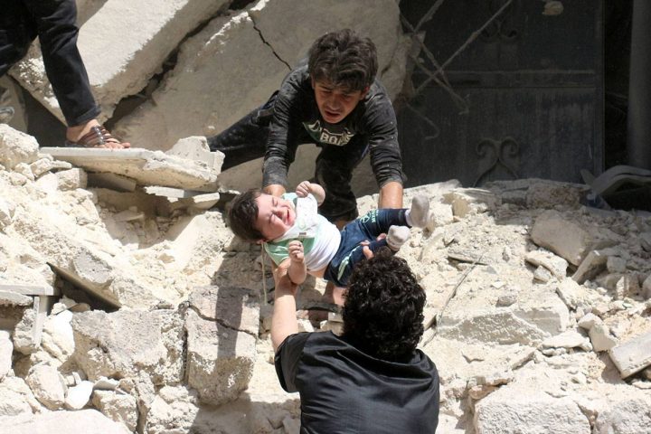 Syrians evacuate a toddler from a destroyed building following a reported air strike on the rebel-held neighbourhood of al-Kalasa in the northern Syrian city of Aleppo, on April 28, 2016. Syrians in many parts of the country are desperate for aid.