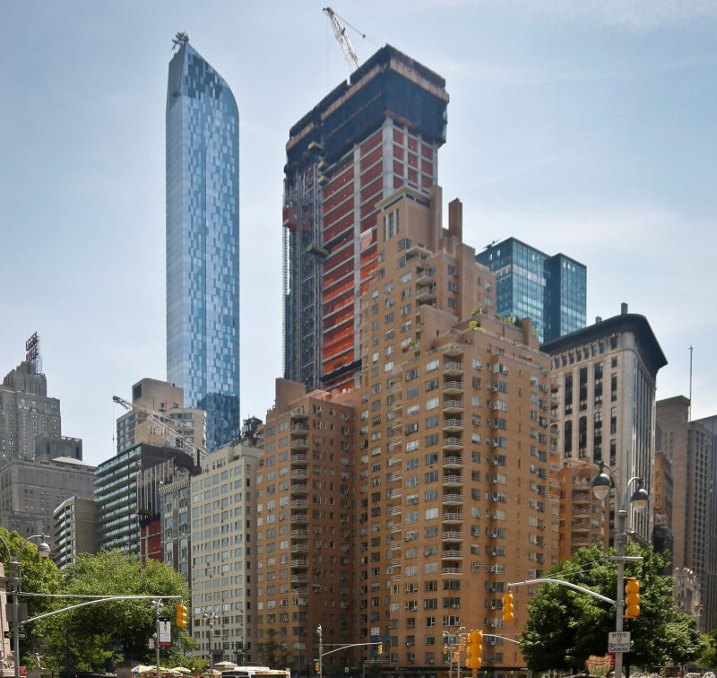 A luxury 90-floor apartment skyscraper called "One57," left, rises above all other buildings overlooking Central Park, while a crane sits atop ongoing construction for a new condominium skyscraper at 220 Central Park South, Thursday May 26, 2016, in New York. 