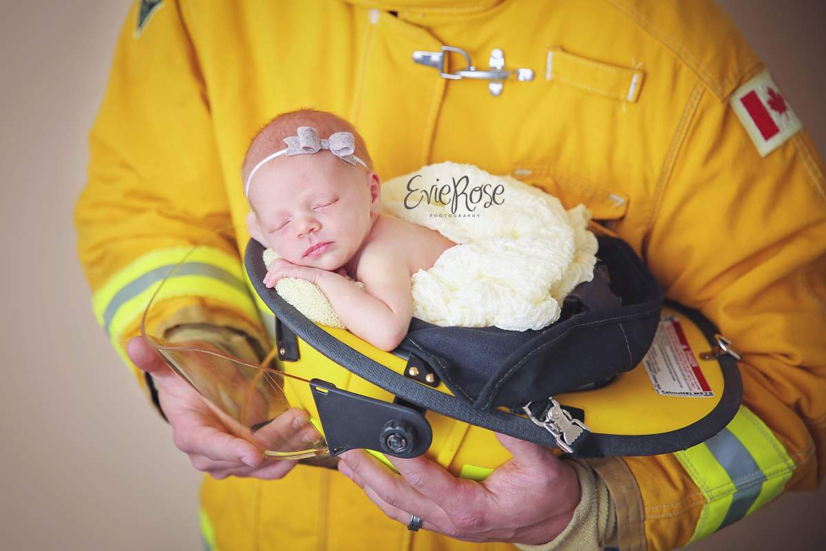 Photographer Kym Poelzer took a picture of Brunet’s husband wearing a borrowed firefighter’s outfit and holding the baby.