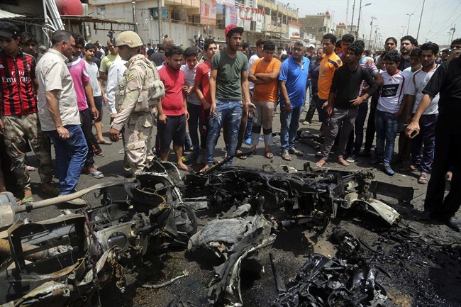 Security forces and citizens inspect the scene after a car bomb explosion at a crowded outdoor market in the Iraqi capital's eastern district of Sadr City, Iraq, Wednesday, May 11, 2016.