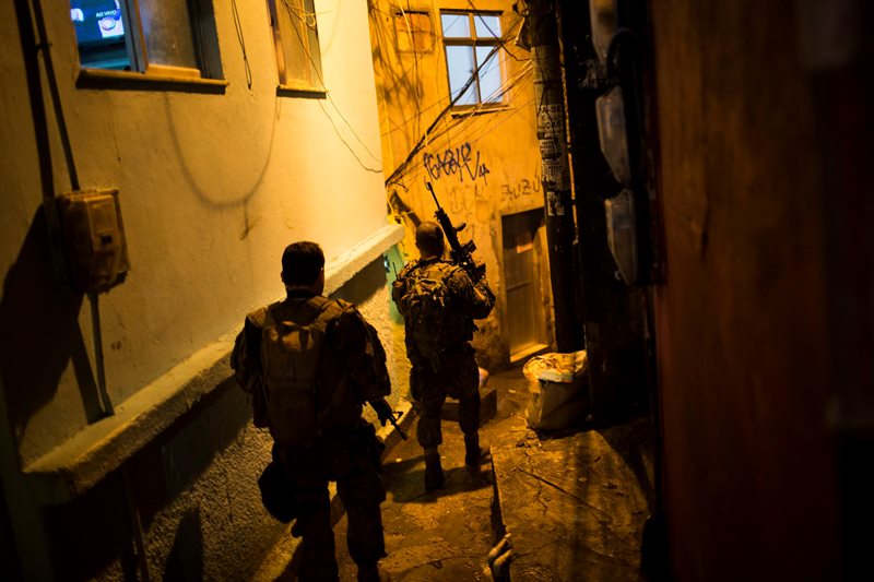 Police officers walk in an alley during a police operation at Rocinha slum in Rio de Janeiro, Brazil, Friday, May 20, 2016. 