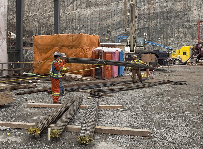 Workers move rebar at the construction site of the hydroelectric facility at Muskrat Falls, Newfoundland and Labrador on Tuesday, July 14, 2015.
