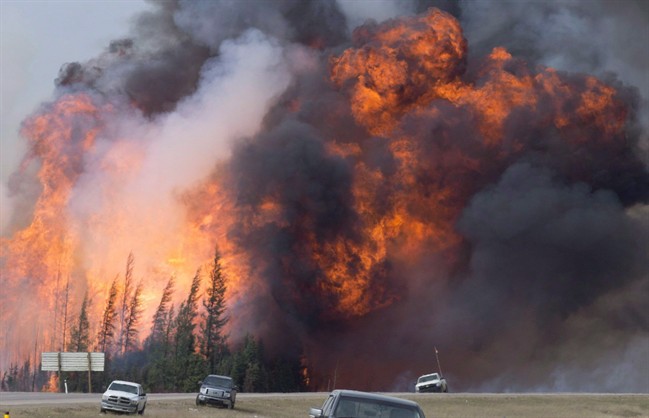 A giant fireball is visible as a wildfire rips through the forest by Highway 63, 16 kilometres south of Fort McMurray, Alta on Saturday, May 7, 2016. 