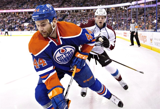 Colorado Avalanche's Carl Soderberg (34) battles in the corner with Edmonton Oilers' Zack Kassian (44) during second period NHL action, in Edmonton, Alta., on Saturday, Feb. 20, 2016. The Oilers have signed Kassian to a one-year contract.