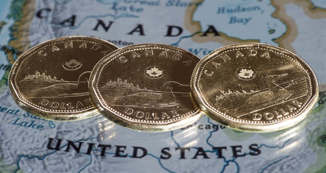 Canadian dollar coins, or Loonies, are displayed on a map of North America in this January 9, 2014, file photo in Montreal. 