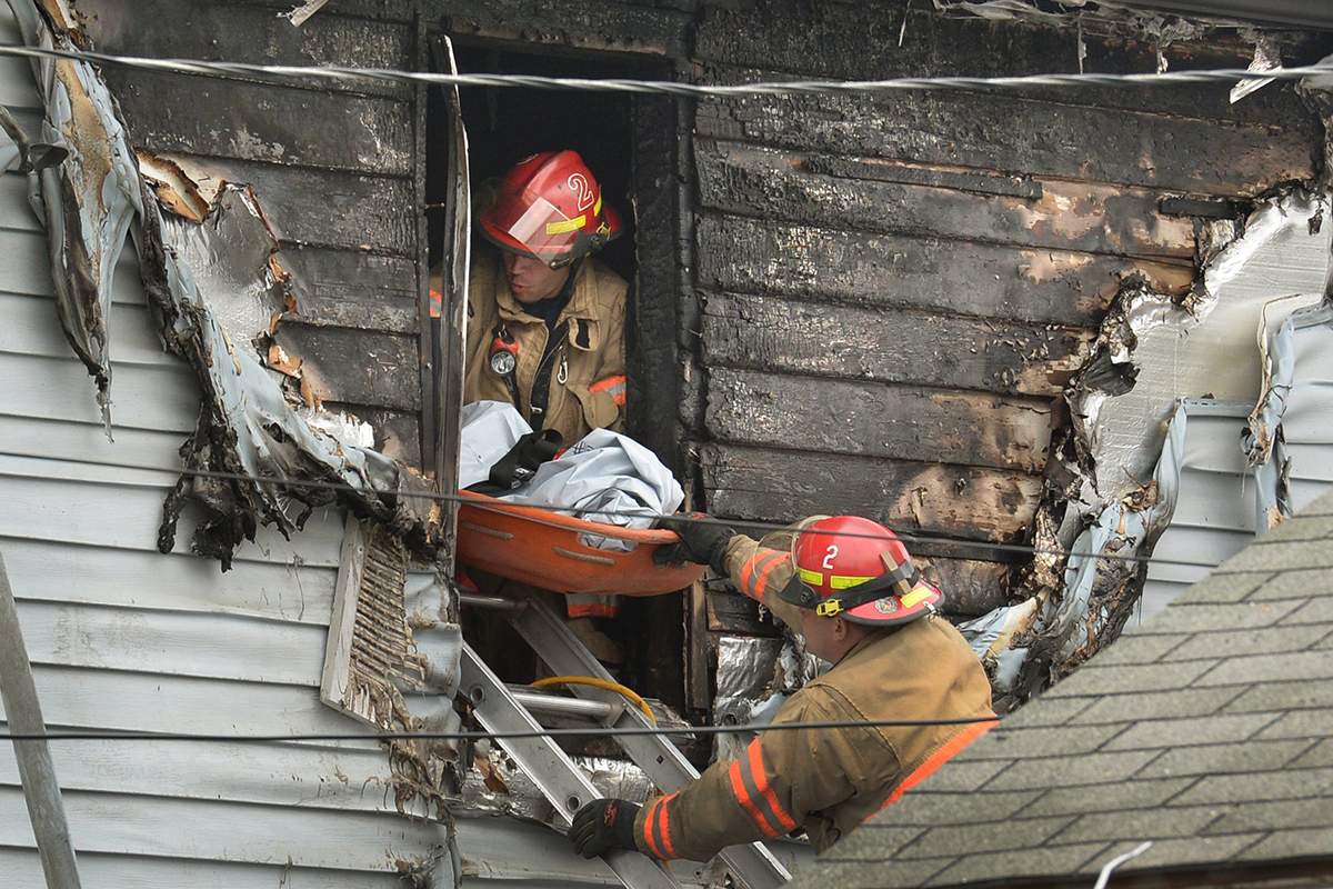 Syracuse firefighters remove a body through an upstairs window at the scene of a fatal fire Friday May 6, 2016 in Syracuse, N.Y. 
