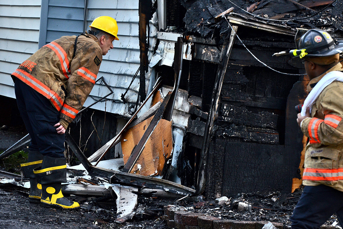 Syracuse firefighters look at the burnt structure at the scene of a fatal fire, Friday May 6, 2016, in Syracuse, N.Y.