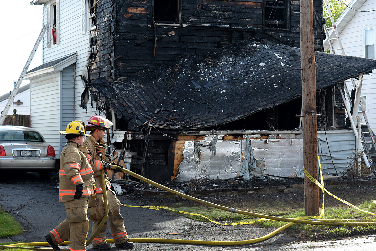 Syracuse firefighters begin to clean up at the scene of a fatal fire, Friday May 6, 2016, in Syracuse, N.Y.