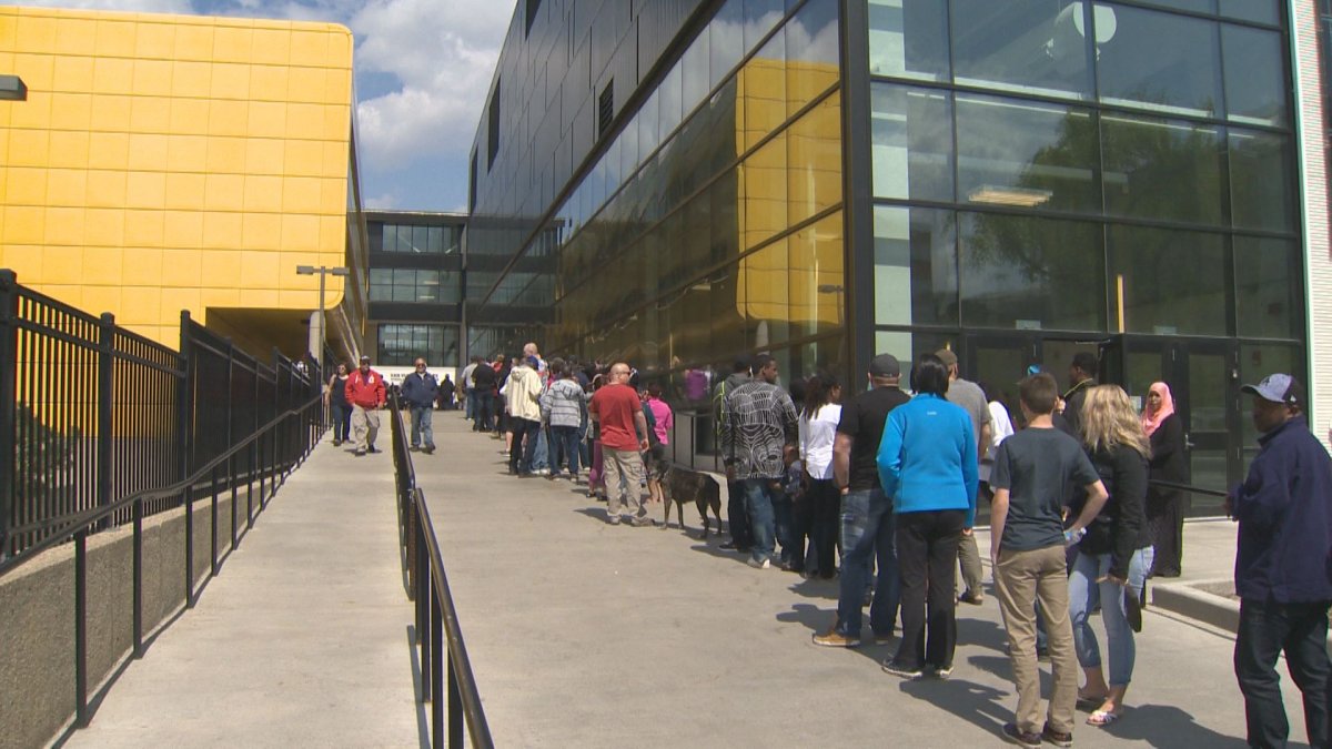 Fort McMurray wildfire evacuees line up outside Edmonton's Butterdome to pick up debit cards from the province, May 11, 2016.
