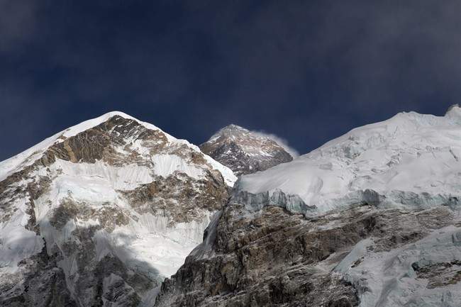 FILE - In this March 7, 2016 file photo, Mount Everest, in middle, altitude 8,848 meters (29,028 feet), is seen on the way to base camp. High winds have delayed dozens of climbers trying to reach the summit of Mount Everest, a mountaineer official said Wednesday, May 18, 2016. (AP Photo/Tashi Sherpa, File).